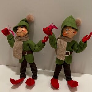 Annalee elf with green coat and hat, holding a cardinal. 2014 edition